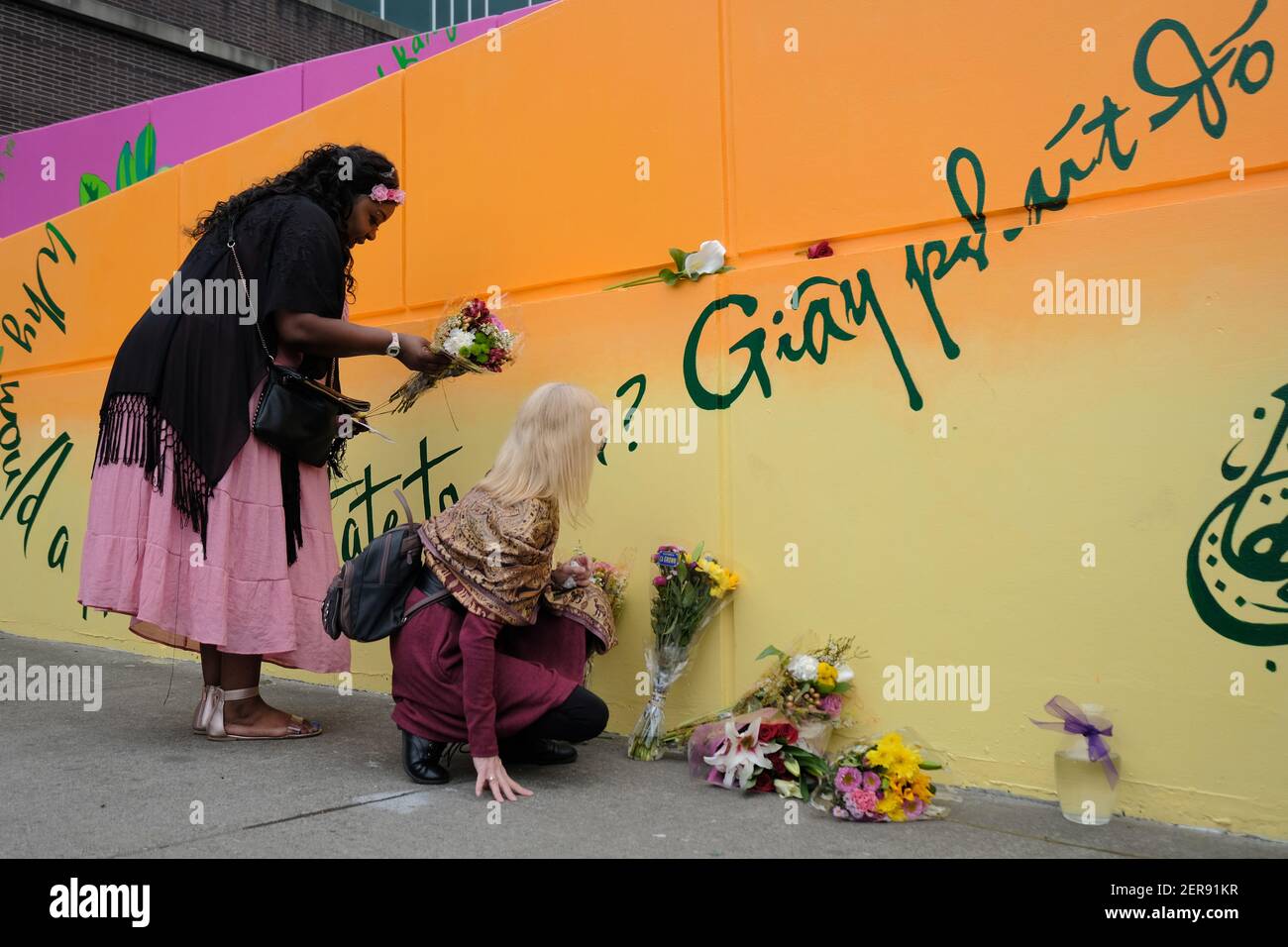 Dyjuana Hudson (left) lays flowers as people gather at the Hollywood ...