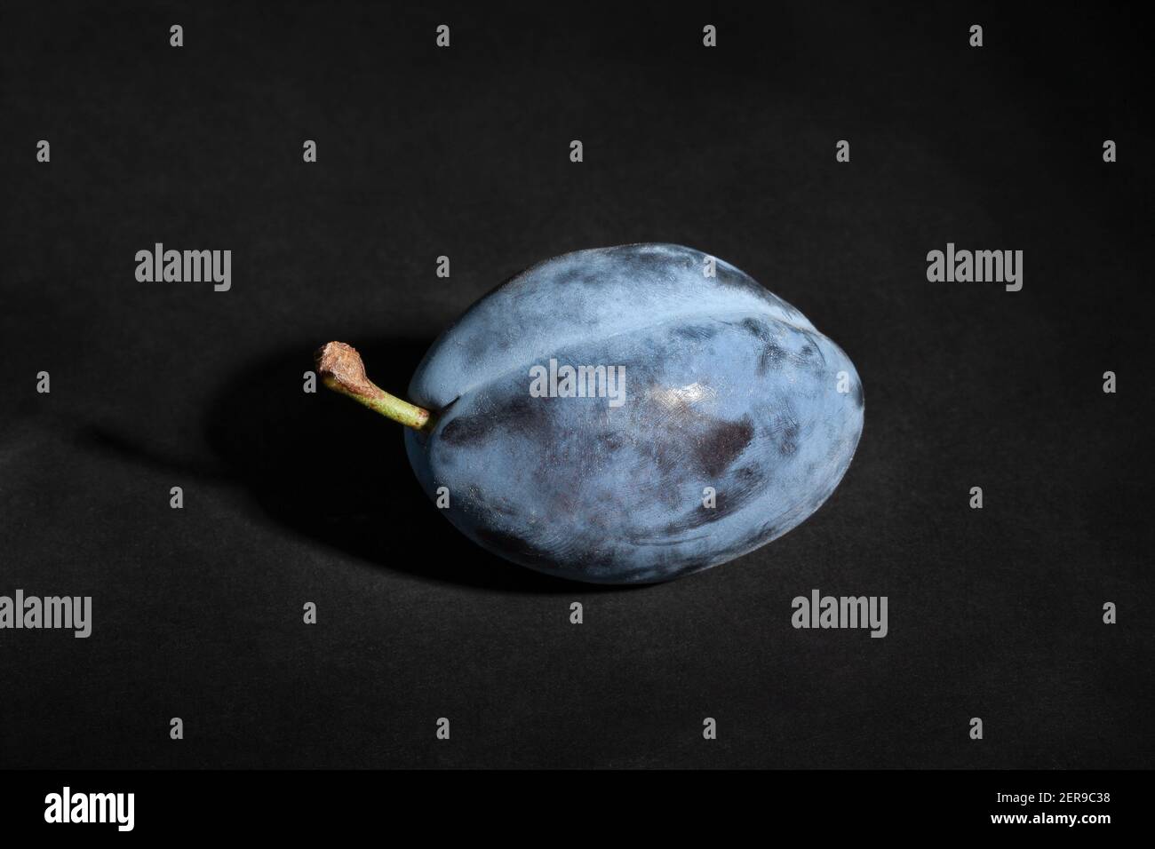 blue plums on black background Stock Photo