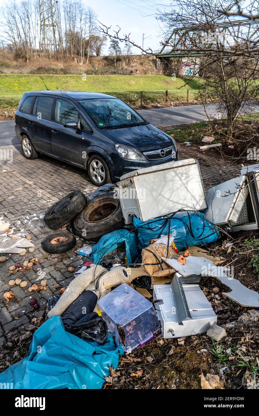 Illegal waste disposal in a car park, at a wooded area, tyres, furniture, refrigerators, household waste, oil cans, Oberhausen NRW, Germany, Stock Photo