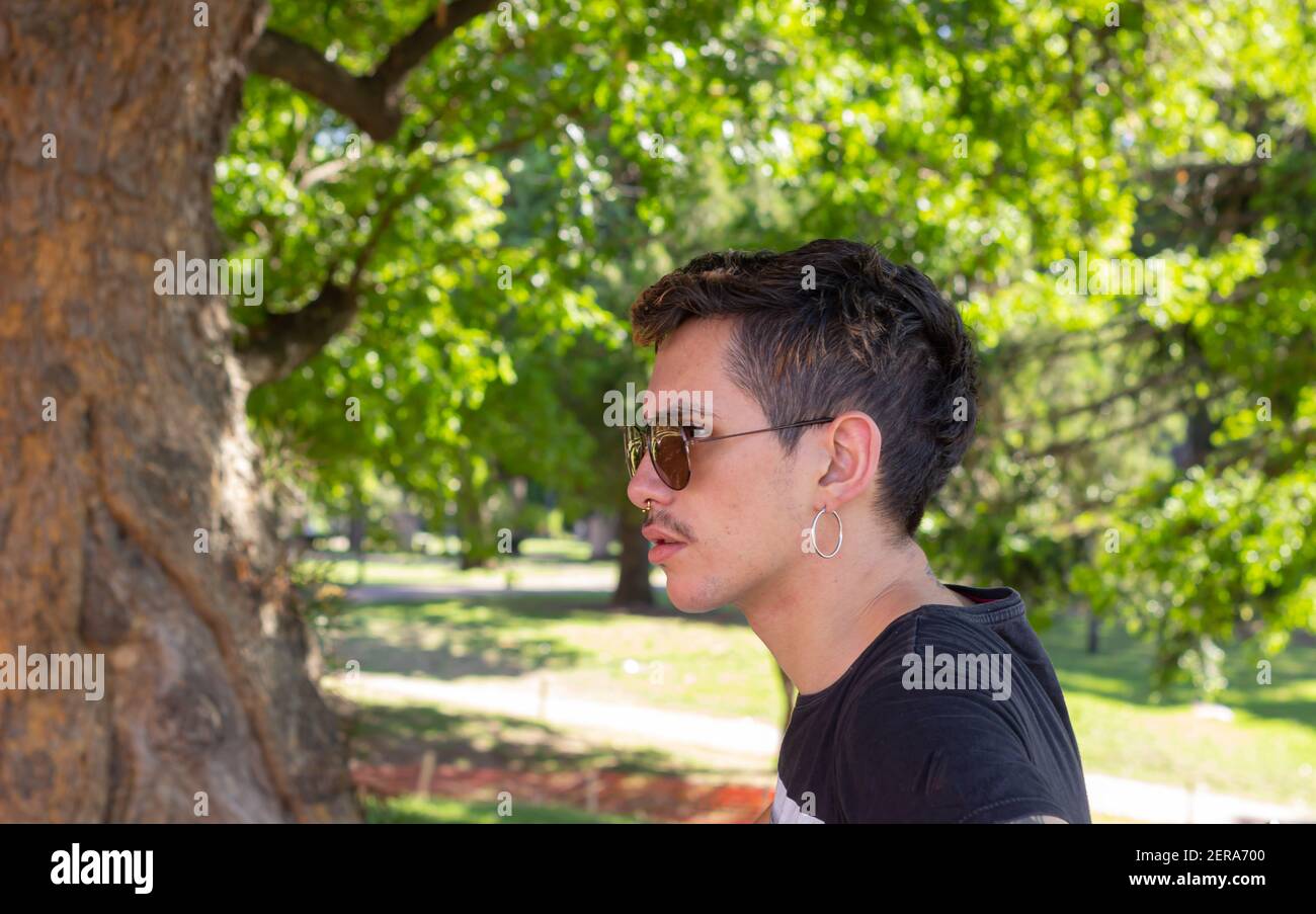 Young man with sun glasses in a park on a sunny day. Stock Photo