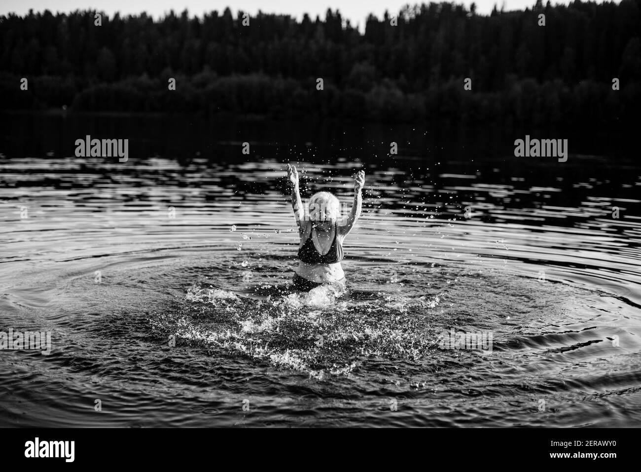 An elderly woman in the summer river. Black and white photo. Stock Photo