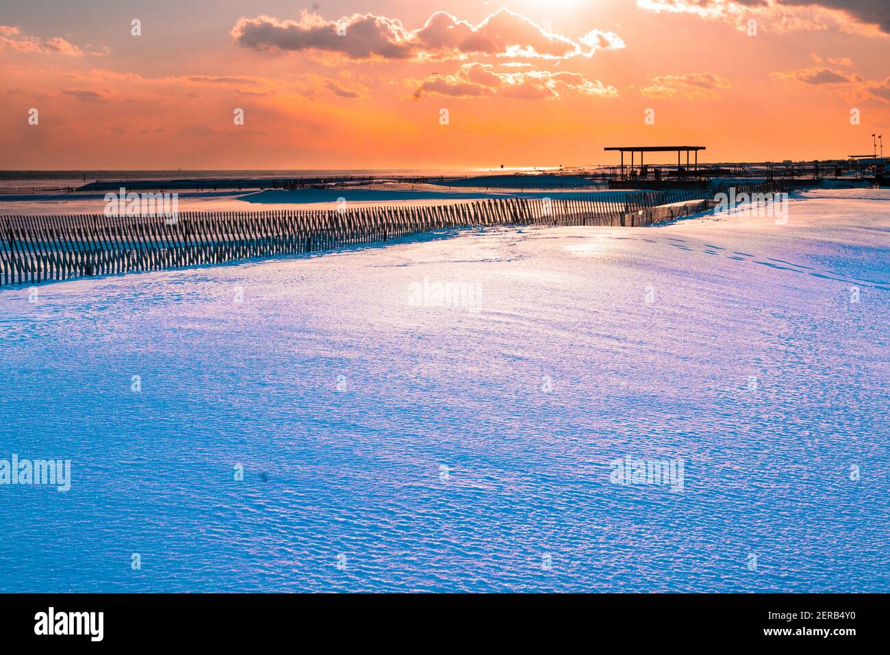 Winter scene under color sky at sunset on snow covered beach. Jones Beach State Park., Long Island NY Stock Photo
