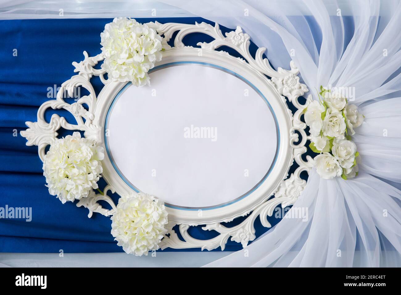 A round frame with a white space for text and design, decorated with flowers in the interior. Stock Photo