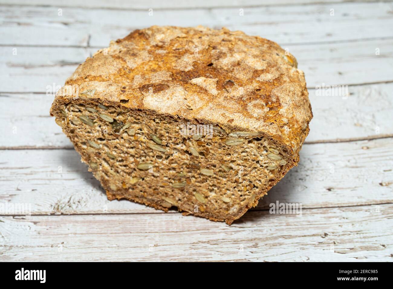 Homemade seeded whole grain sourdough bread with oats, sunflower seeds, pumpkin sees and flaxseed. Stock Photo