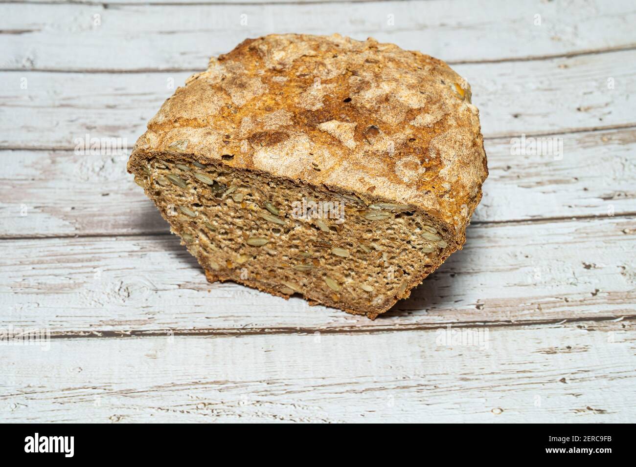 Homemade seeded whole grain sourdough bread with oats, sunflower seeds, pumpkin sees and flaxseed. Stock Photo