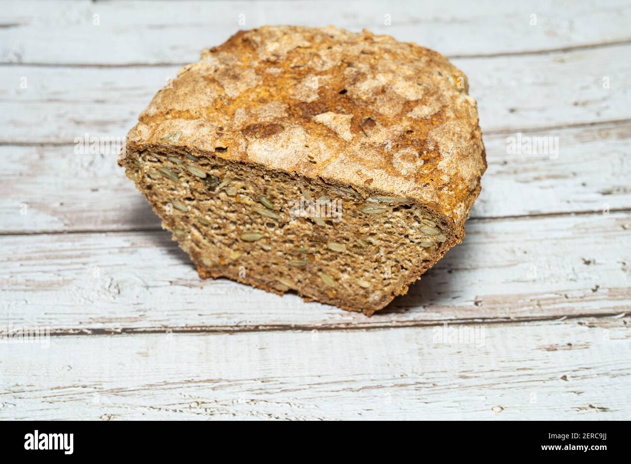 Homemade seeded whole grain sourdough bread with oats, sunflower seeds, pumpkin sees and flaxseed. Stock Photo