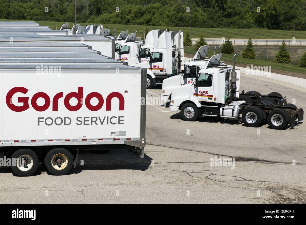 Semi trucks and trailers featuring Gordon Food Service logos outside of a distribution center in