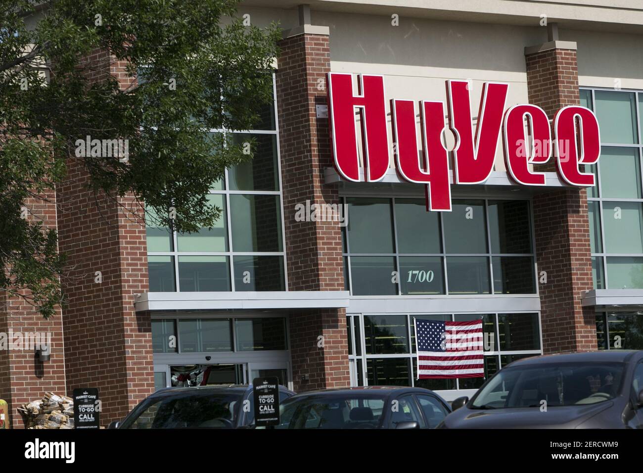 A logo sign outside of a HyVee retail grocery store in West Des Moines