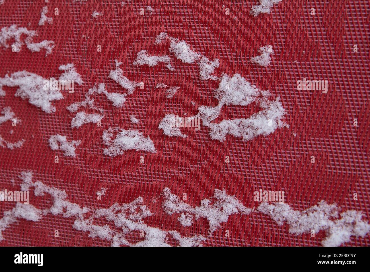 The TEXTURE of the fabric is red. Snow lies on the background. Background for wallpaper Stock Photo