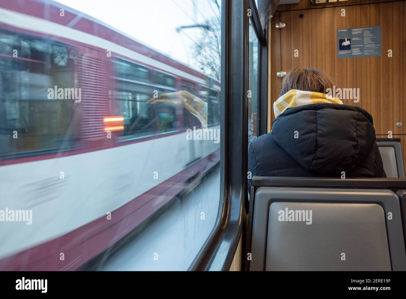 Female passenger with face protection mask who sit in light rail tram