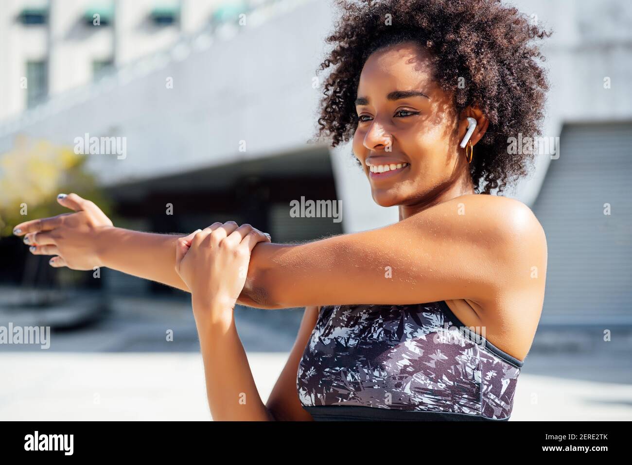 Afro athletic woman stretching arms before exercise Stock Photo Alamy