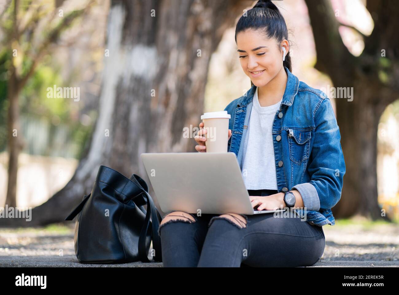 Woman using her laptop outdoors Stock Photo - Alamy