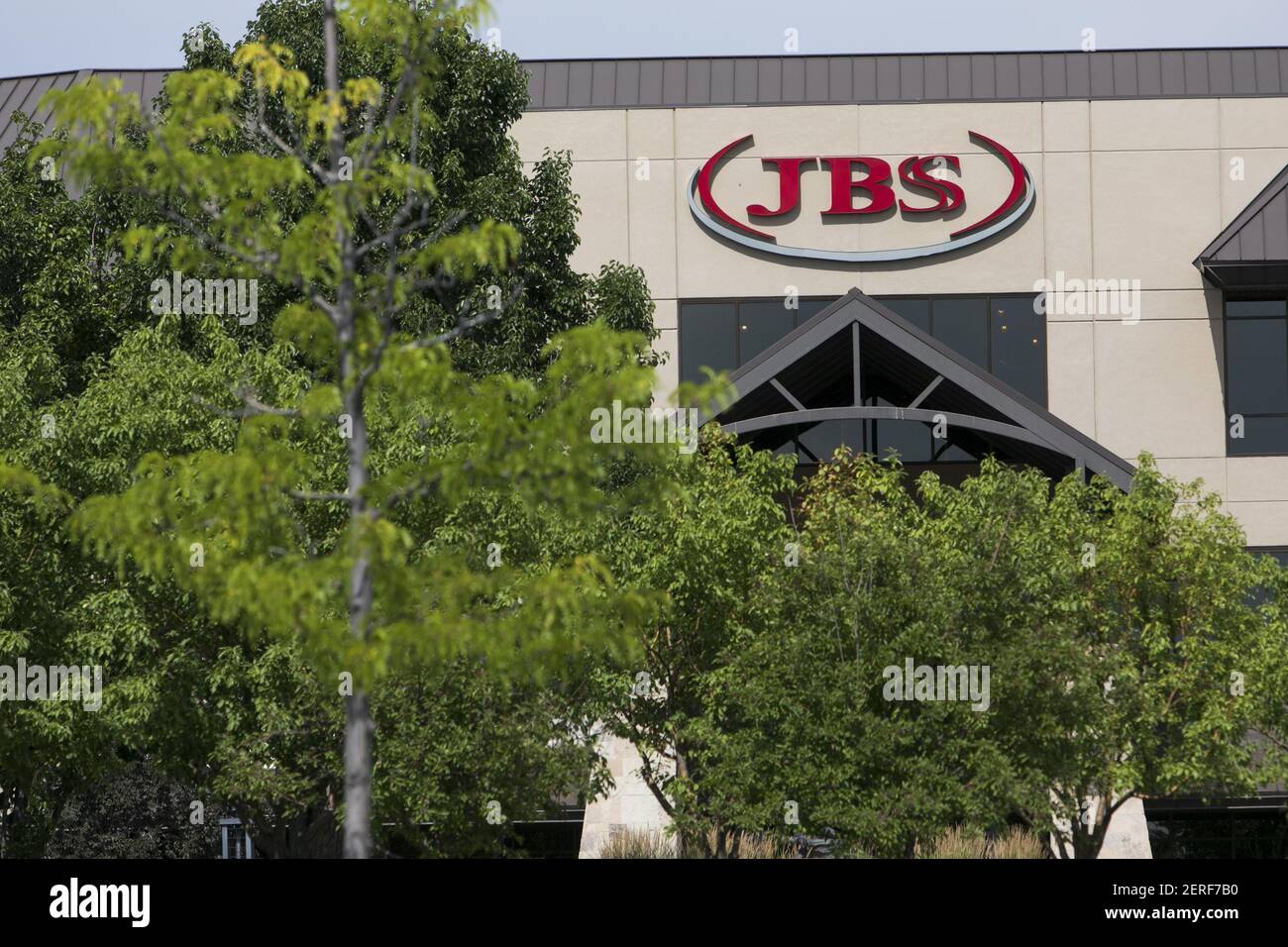 A logo sign outside of the headquarters of JBS USA Holdings, Inc., in
