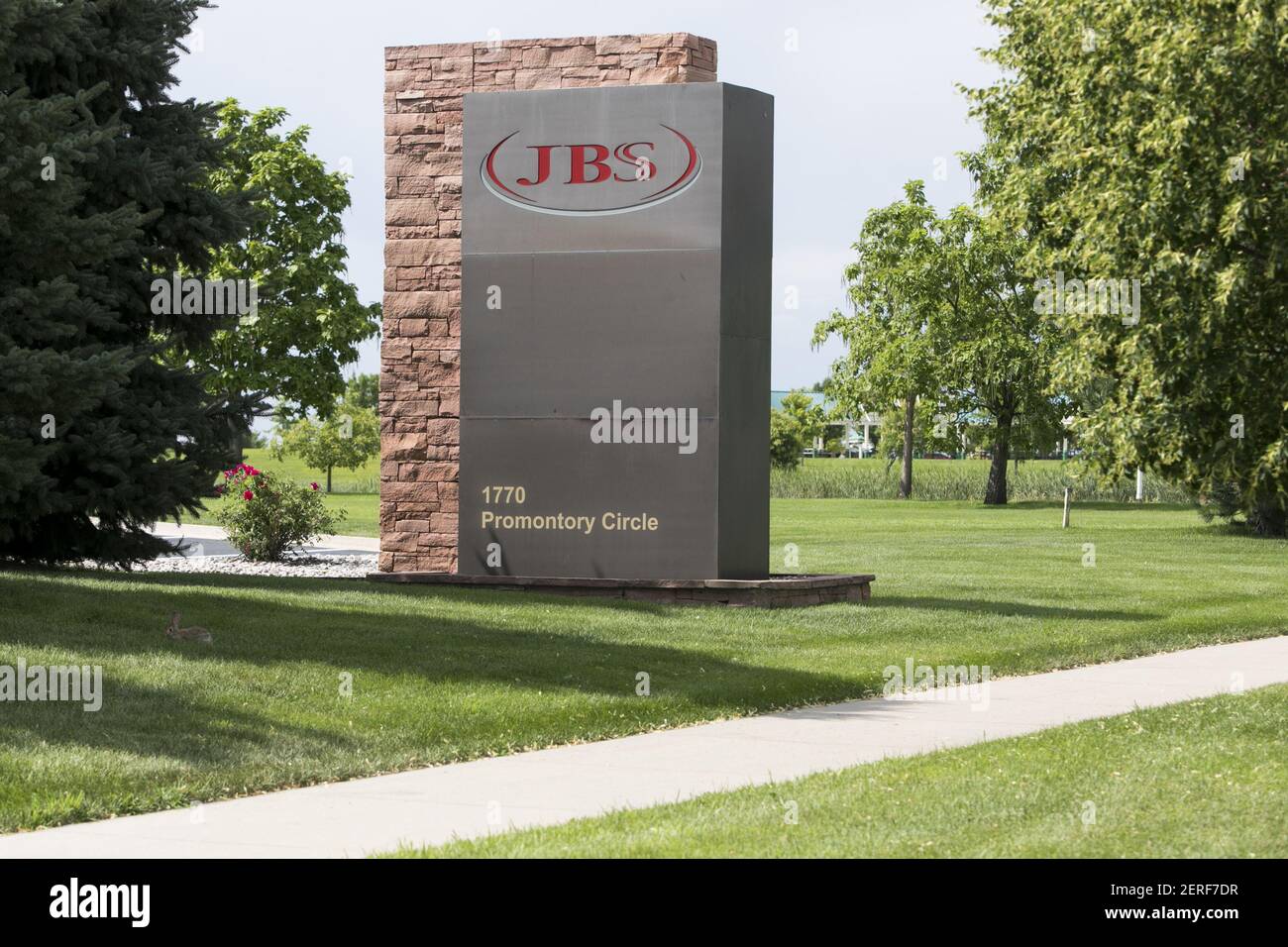 A logo sign outside of the headquarters of JBS USA Holdings, Inc., in