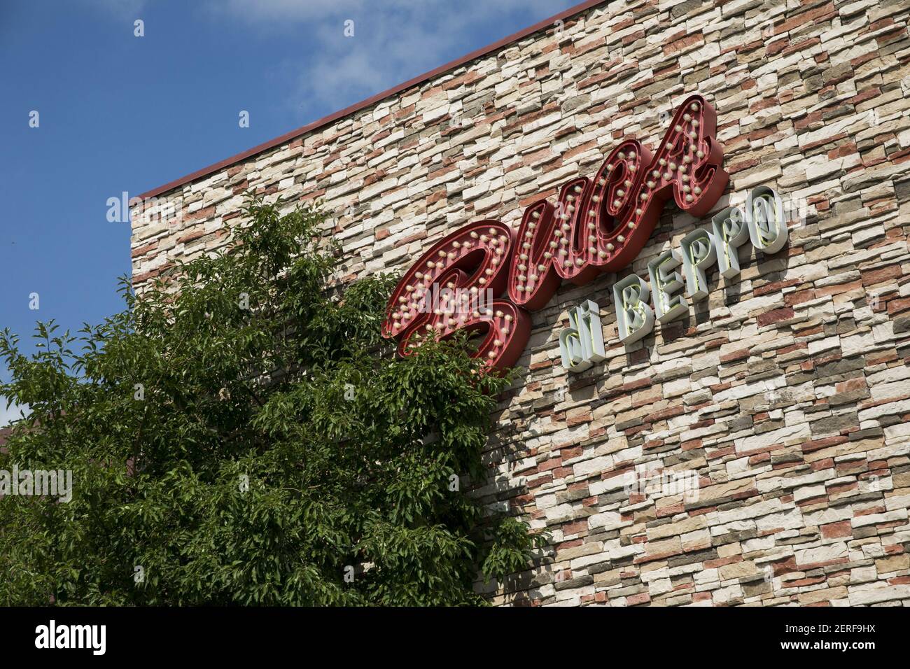 A logo sign outside of a Buca di Beppo restaurant location in ...