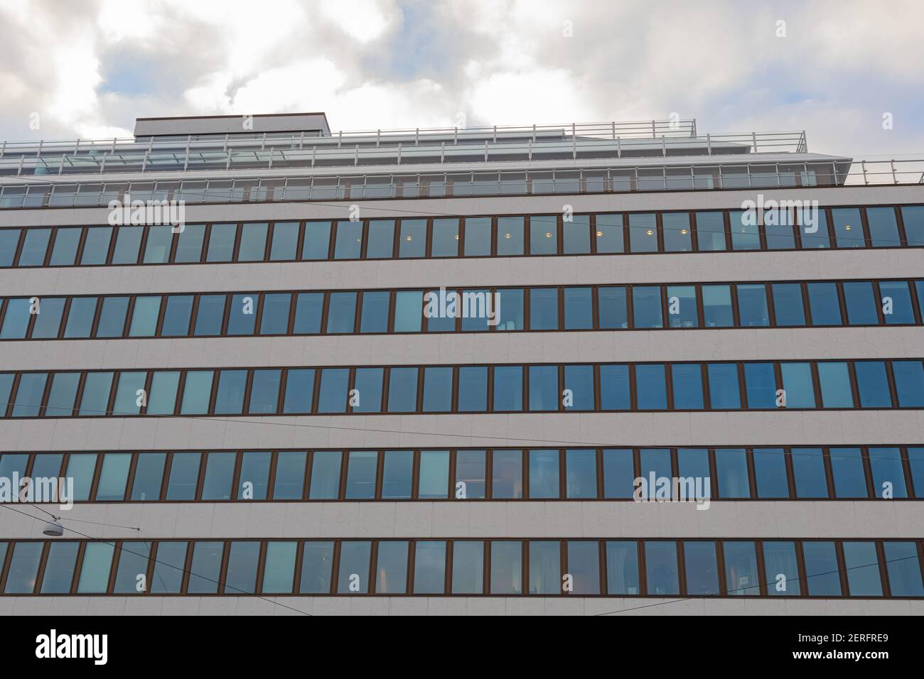 Glass facade of modern office building with blue sky and clouds ...