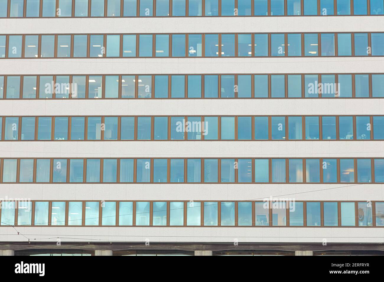Glass facade of modern office building with blue sky and clouds ...
