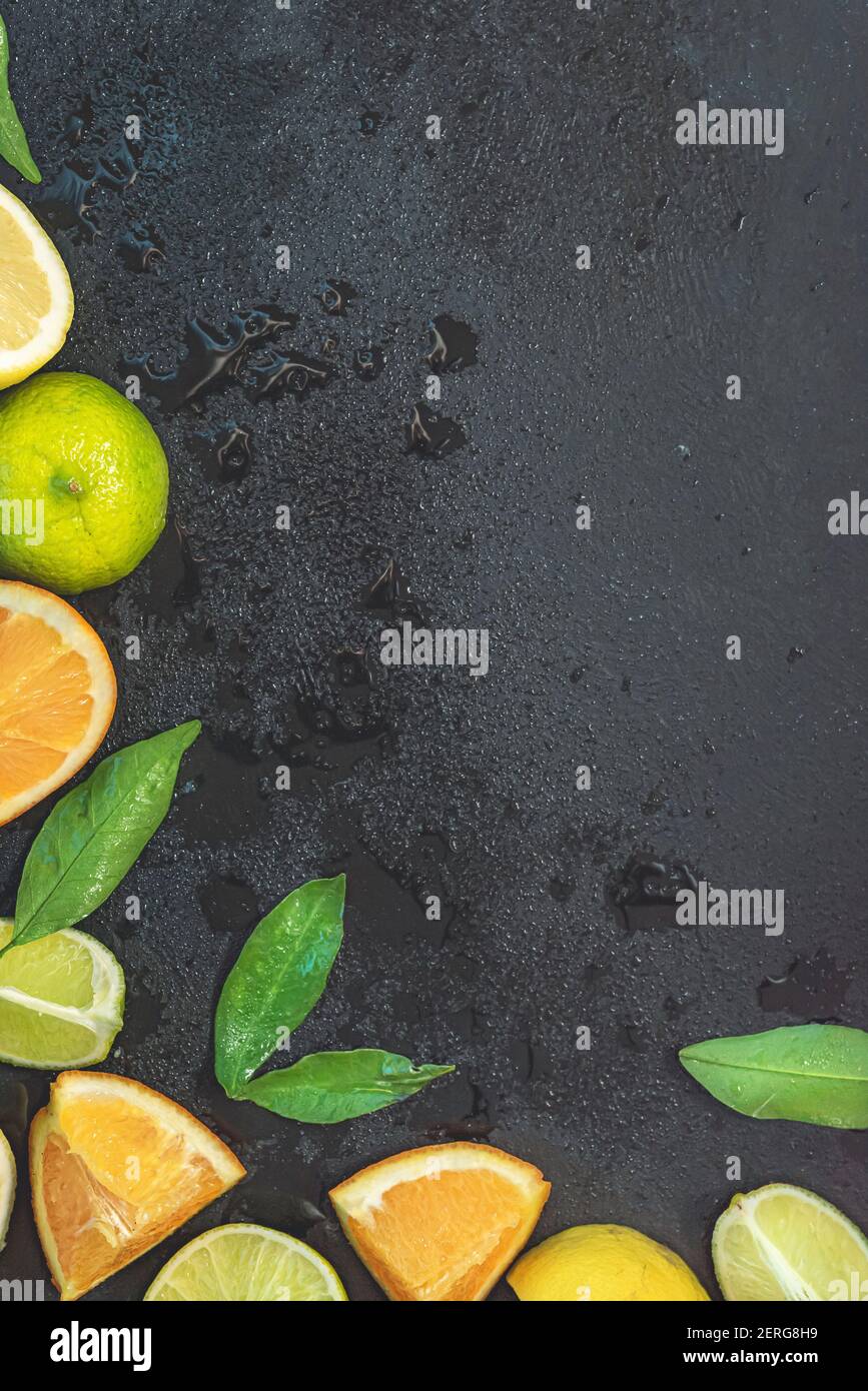 Sliced fresh citrus fruits over black background Stock Photo - Alamy