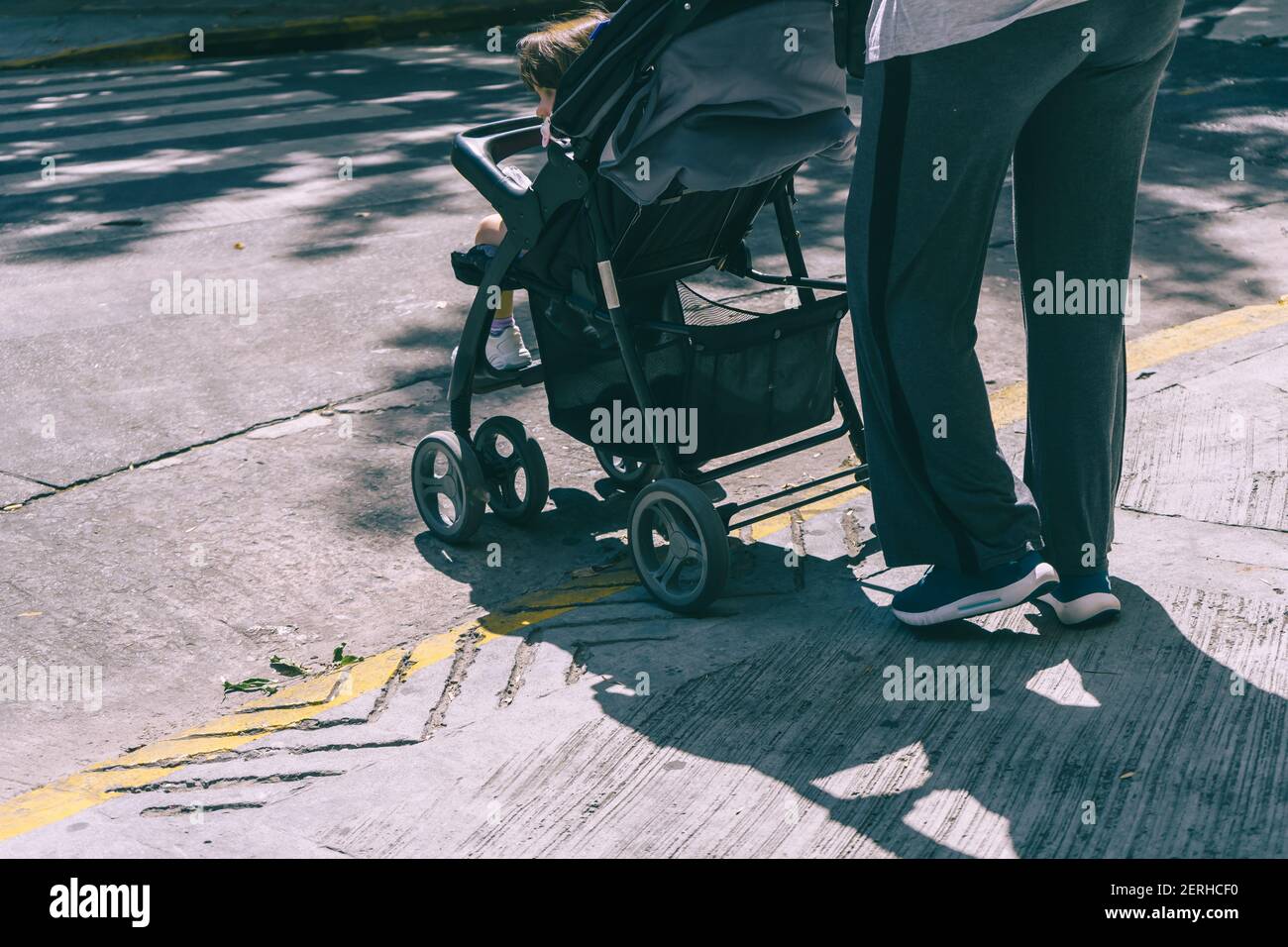 Young woman walking her baby in a buggy Stock Photo Alamy