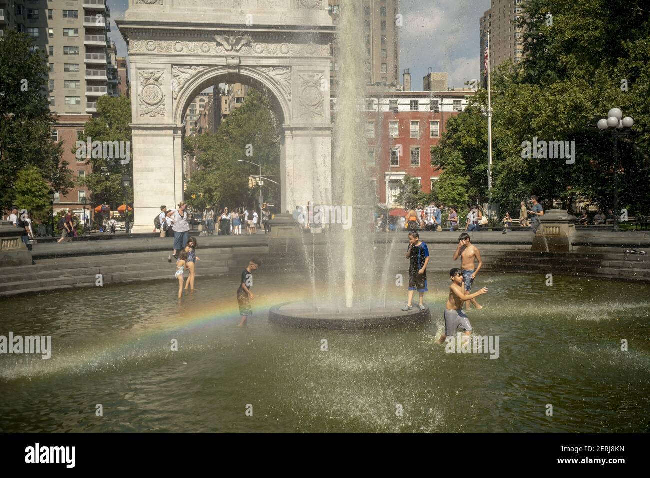 New Yorkers and visitors frolic in the fountain in Washington Square 