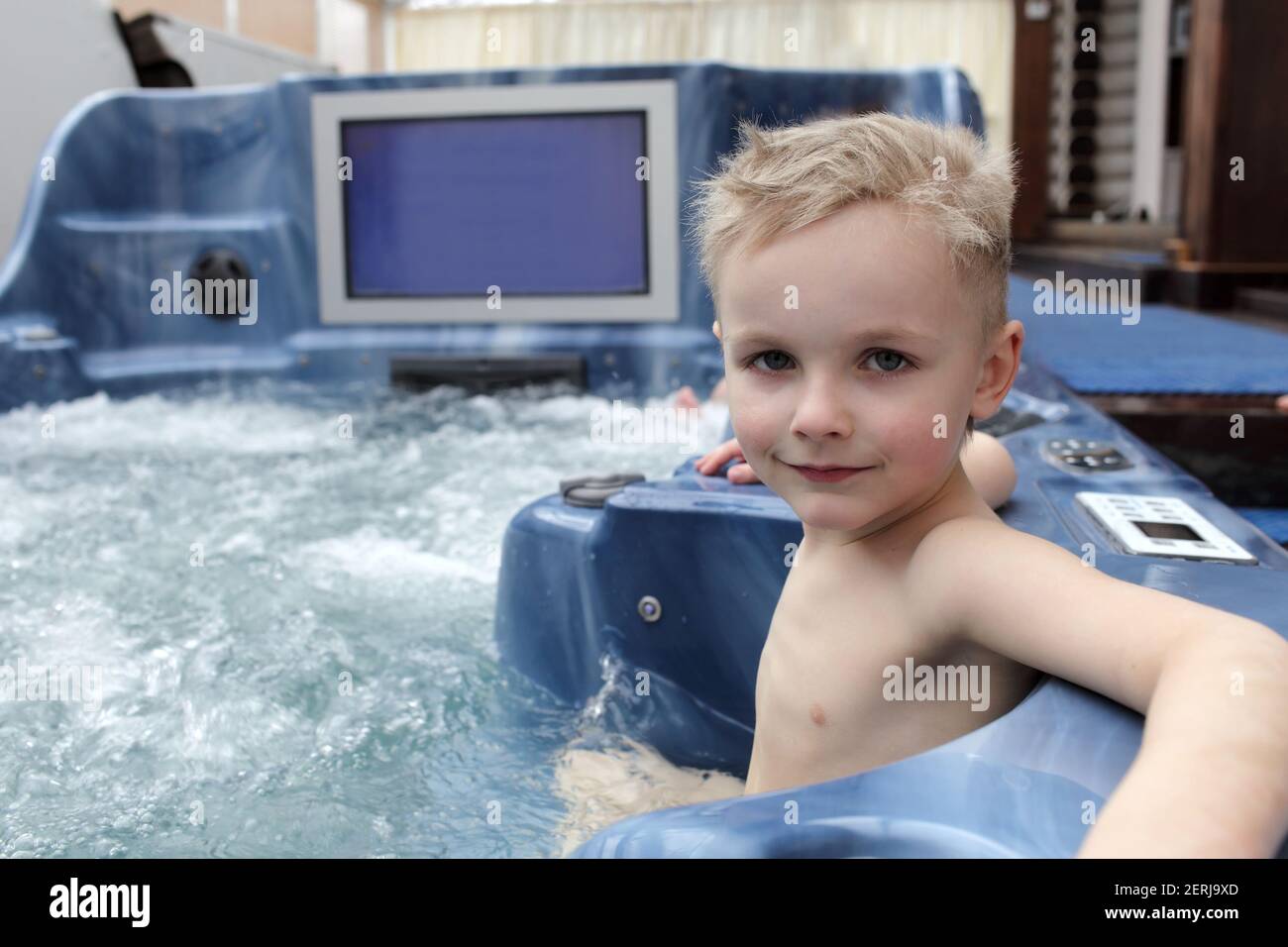 Boy sitting in the warm bubbling water jacuzzi Stock Photo