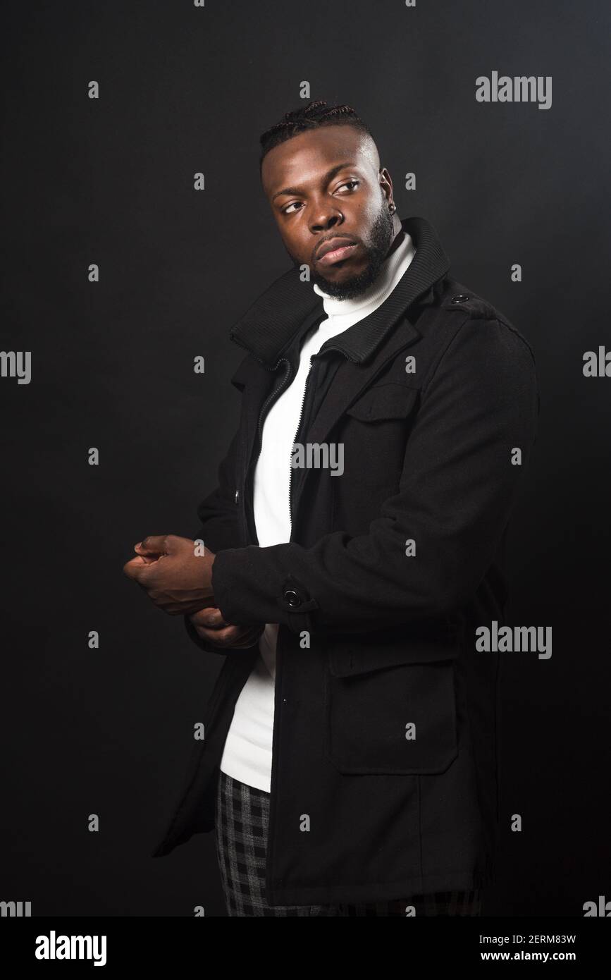 Handsome black man posing. Mid shot. Black background. Stock Photo