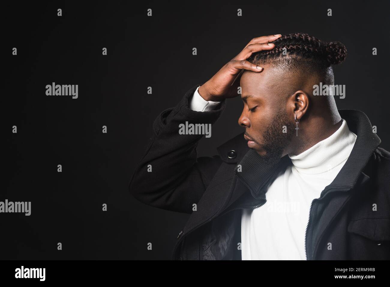 Black man in profile with hand on forehead Stock Photo - Alamy
