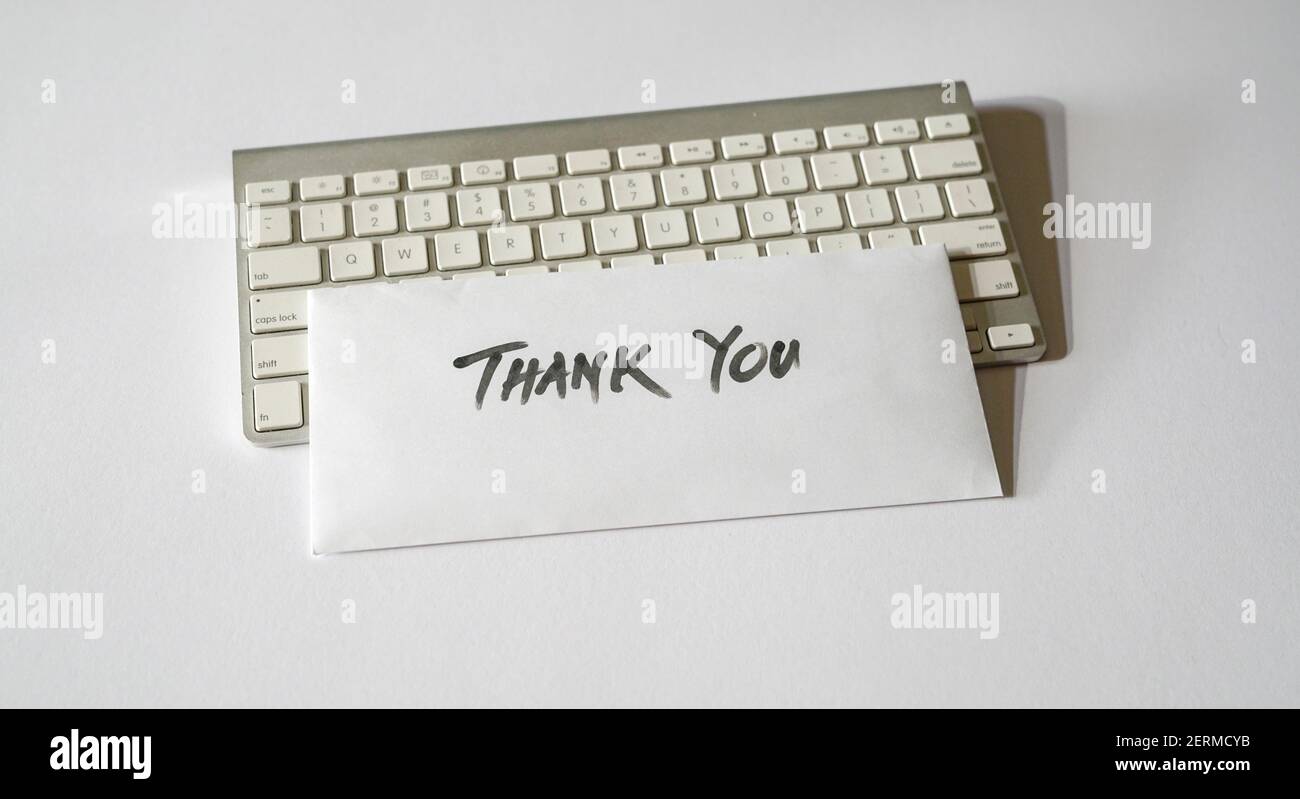 Thank you letter on top of keyboard. Isolated, white background. Stock Photo