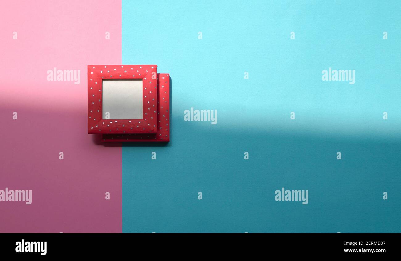 Design concept - top view of two red photo frames isolated on blue and pink background for mockup. Copy space. Stock Photo