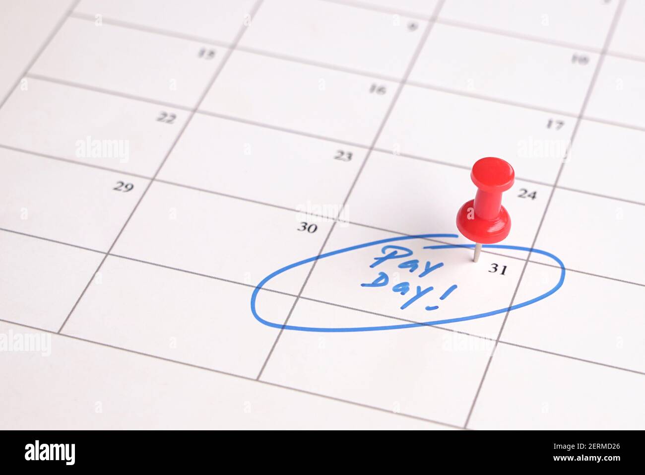 Red pin on calendar with words, pay day written. Salary reminder concept. Stock Photo
