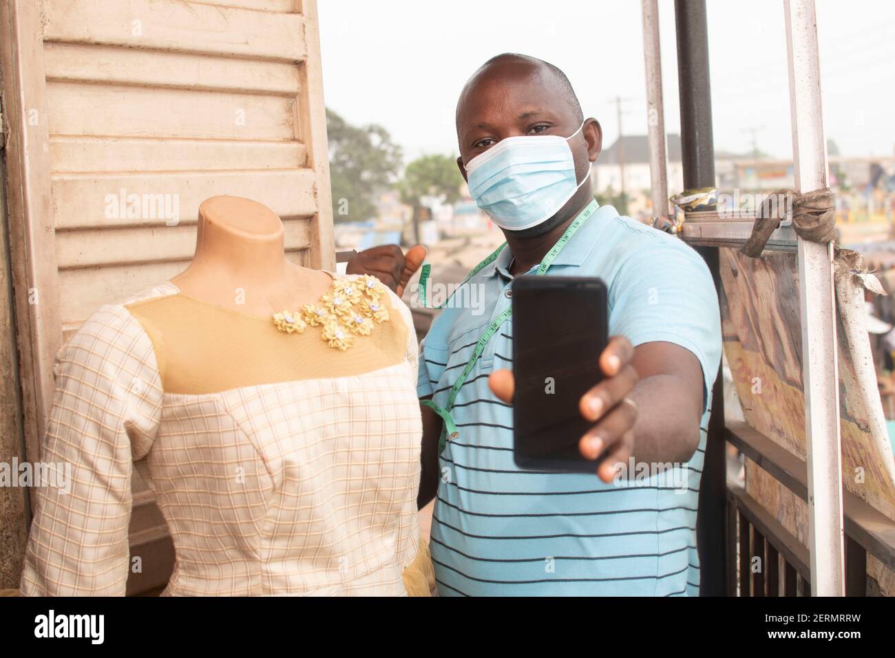 an african tailor holding his phone Stock Photo