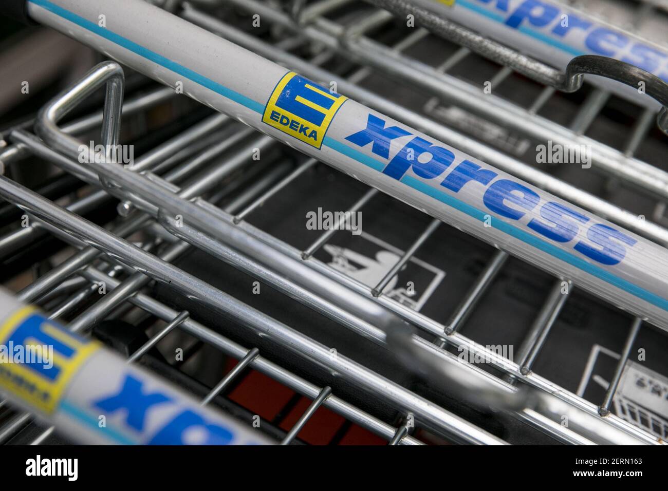 A logo sign outside of an Edeka Express retail grocery store in Munich ...