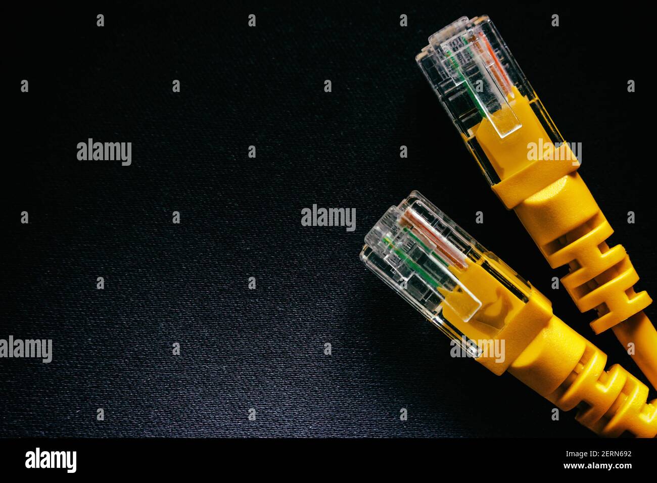 yellow network internet cable on a black background close-up with space ...