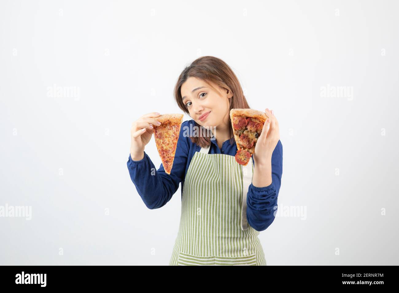 Shot of female cook in apron holding pizza on white background Stock Photo