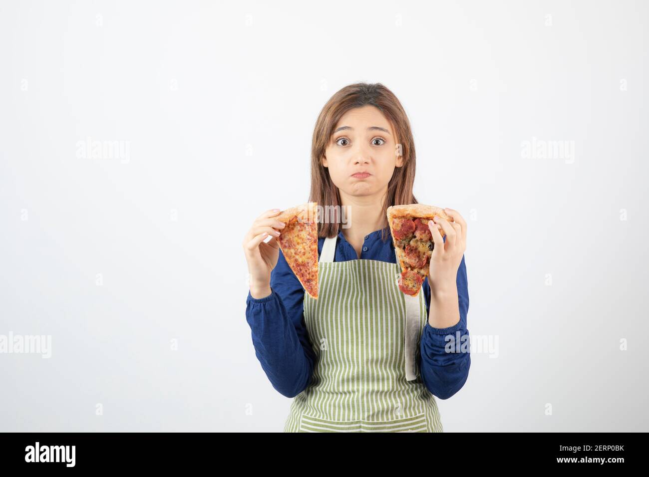 Portrait of female cook in apron holding pizza on white background Stock Photo