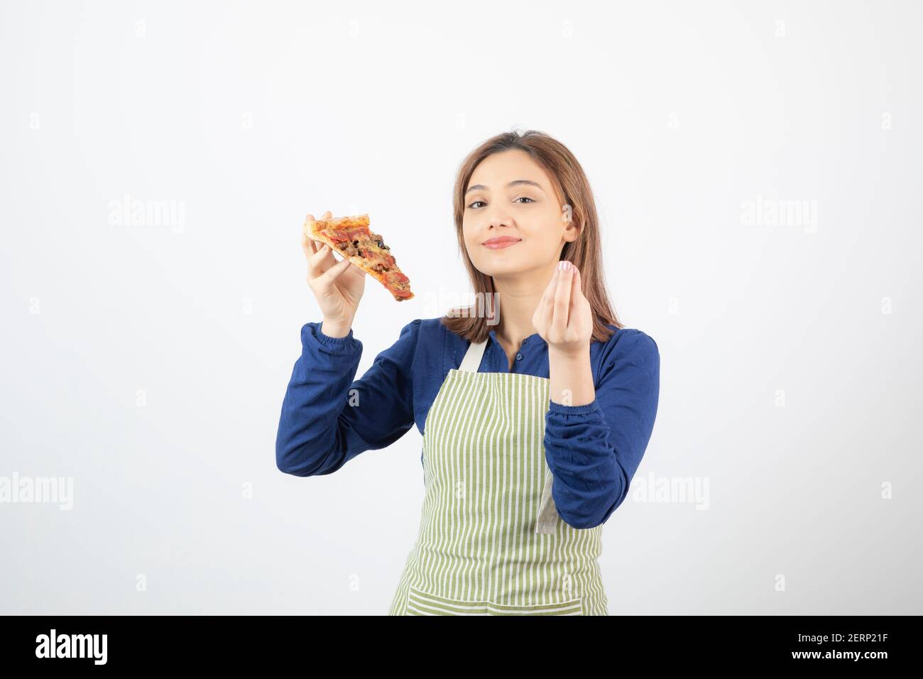 Shot of female cook in apron holding pizza on white background Stock Photo