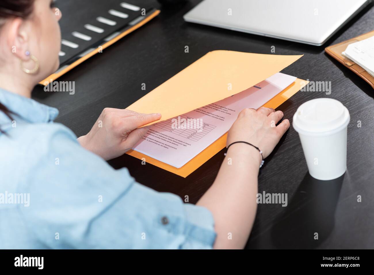 Businesswoman opening folder with paper documents Stock Photo - Alamy