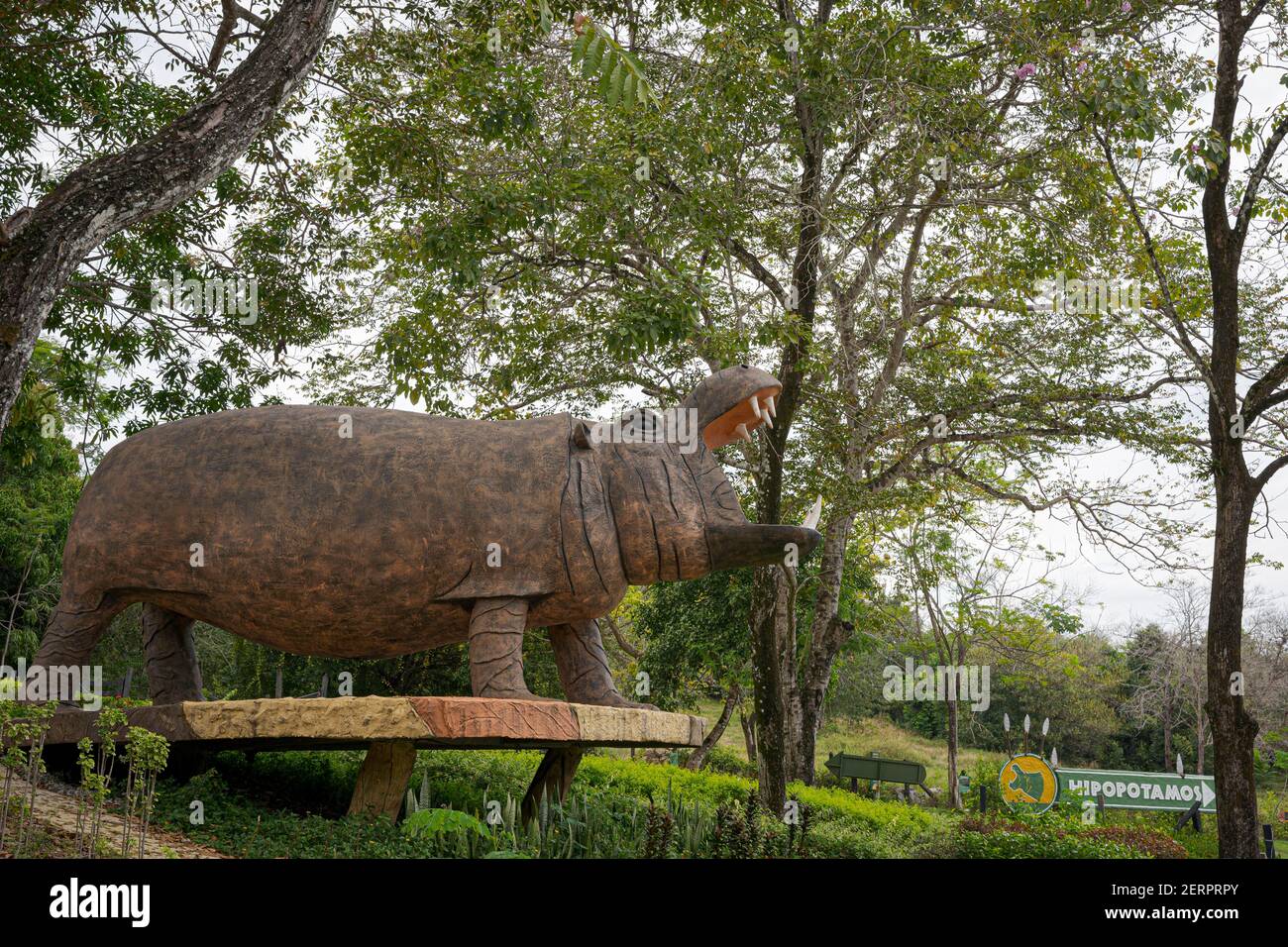 Puerto Triunfo, Colombia. 18th Feb, 2021. A hippo statue and a sign indicate where hippos can be observed within the 'Hacienda Nápoles'. The hippos, which the drug lord Pablo Escobar once brought to Colombia, have multiplied so much that the country is looking for a solution for the animals. Credit: Luis Bernardo Cano/dpa/Alamy Live News Stock Photo