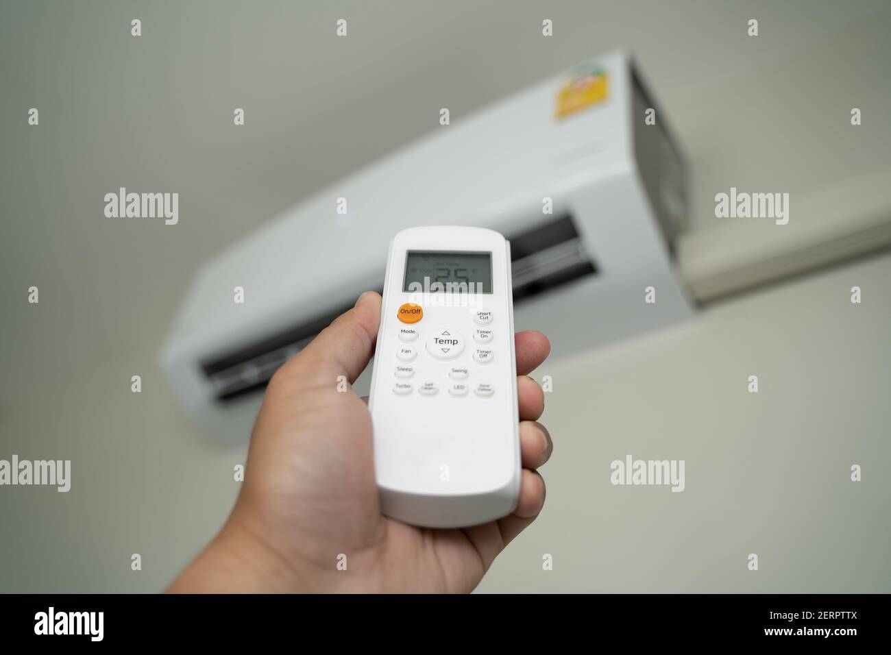 Air conditioner inside top the room man operating remote controller