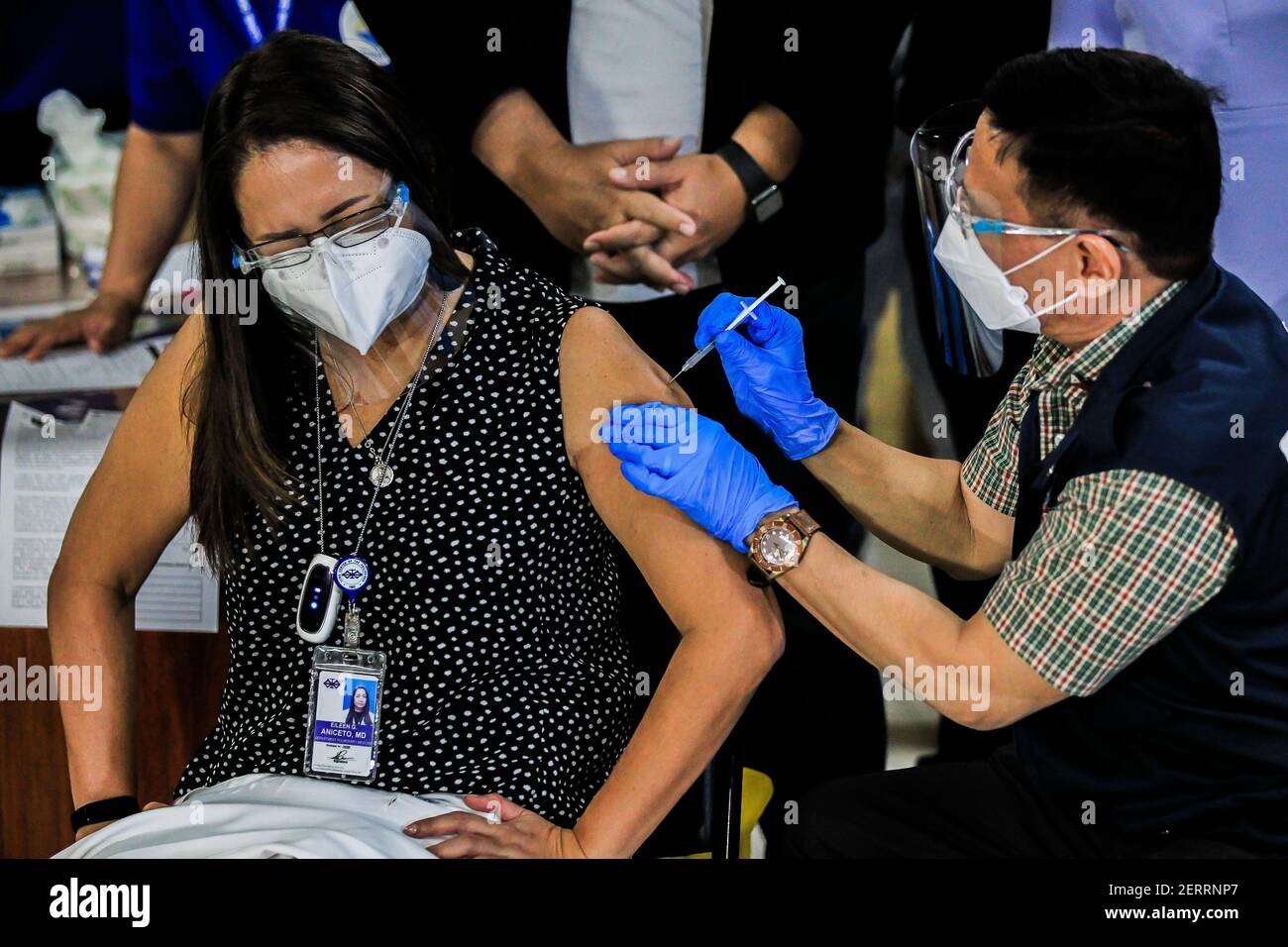 Manila. 1st Mar, 2021. Philippine Department of Health Secretary Francisco Duque III injects a shot of COVID-19 vaccine from China's Sinovac to a doctor on the first day of the vaccination at the Lung Center of the Philippines in Manila, the Philippines on March 1, 2021. The Philippines launched its coronavirus vaccination campaign on Monday, less than a day after the arrival of the Sinovac vaccine CoronaVac donated by China. Credit: Rouelle Umali/Xinhua/Alamy Live News Stock Photo
