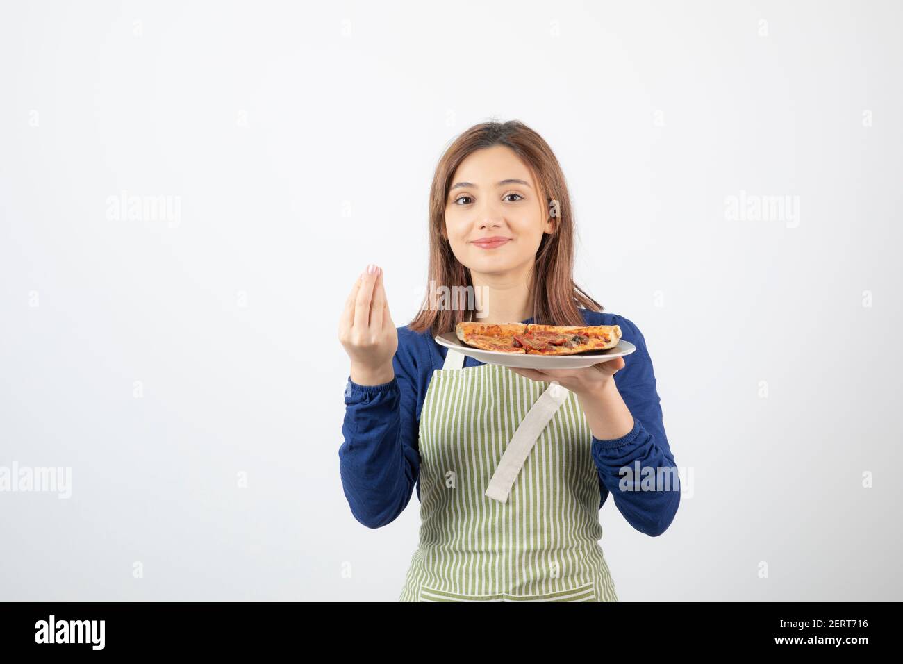 Portrait of female cook in apron holding pizza on white background Stock Photo