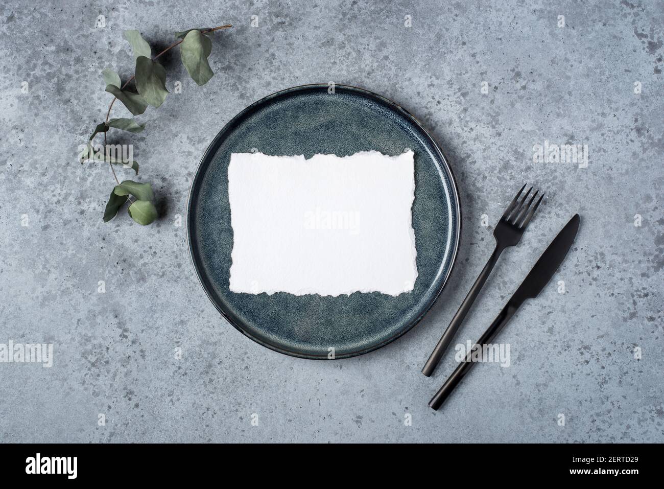 An empty plate and cutlery on a gray table. Stock Photo