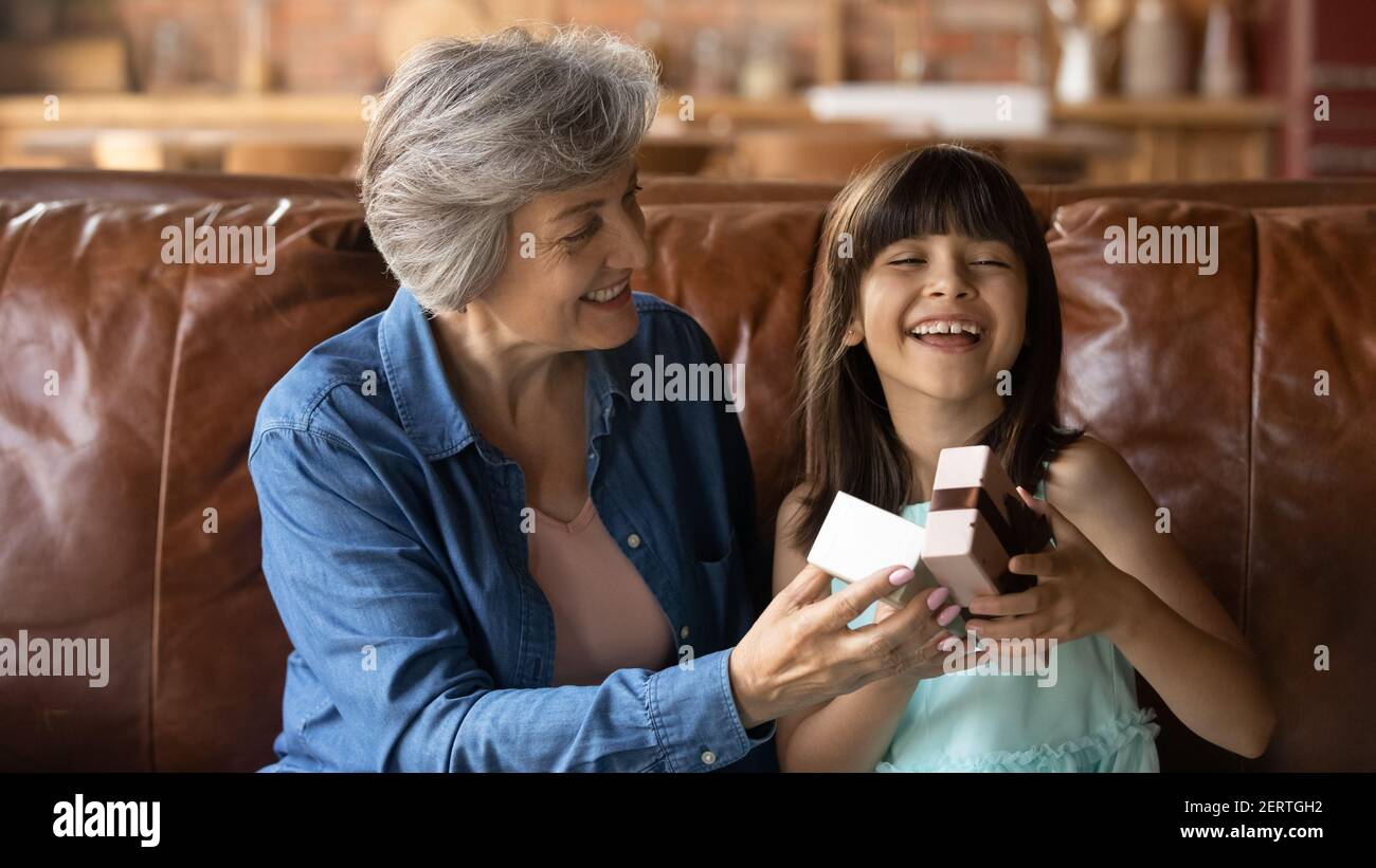 Loving grandmother congratulate excited little granddaughter with birthday Stock Photo