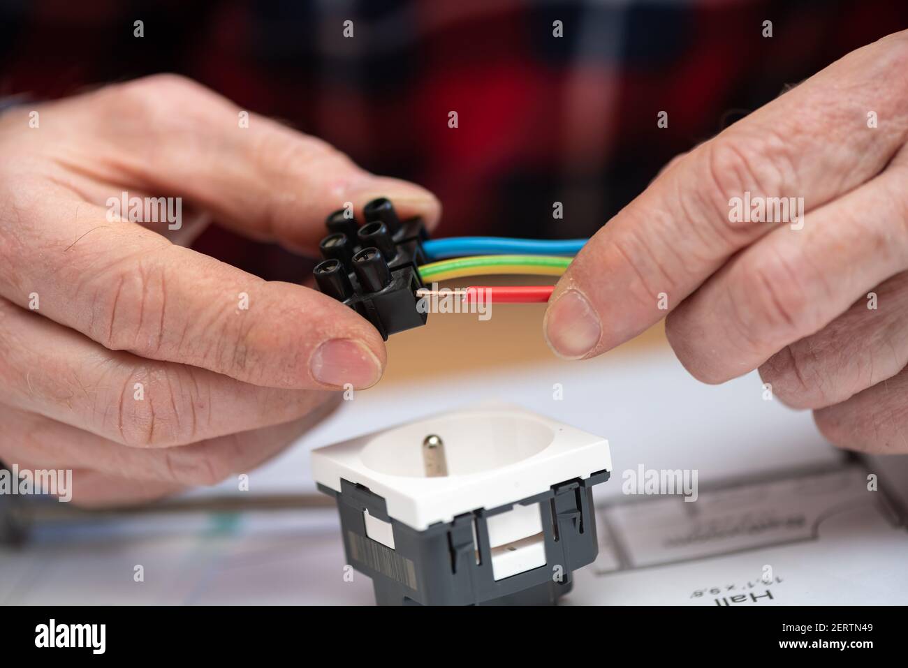 Electrician hands connecting wires in terminal block Stock Photo