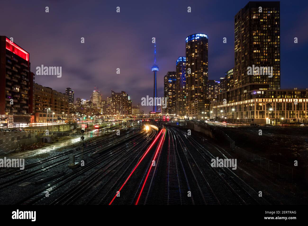 Train tracks in downtown Toronto with CN tower behind Stock Photo