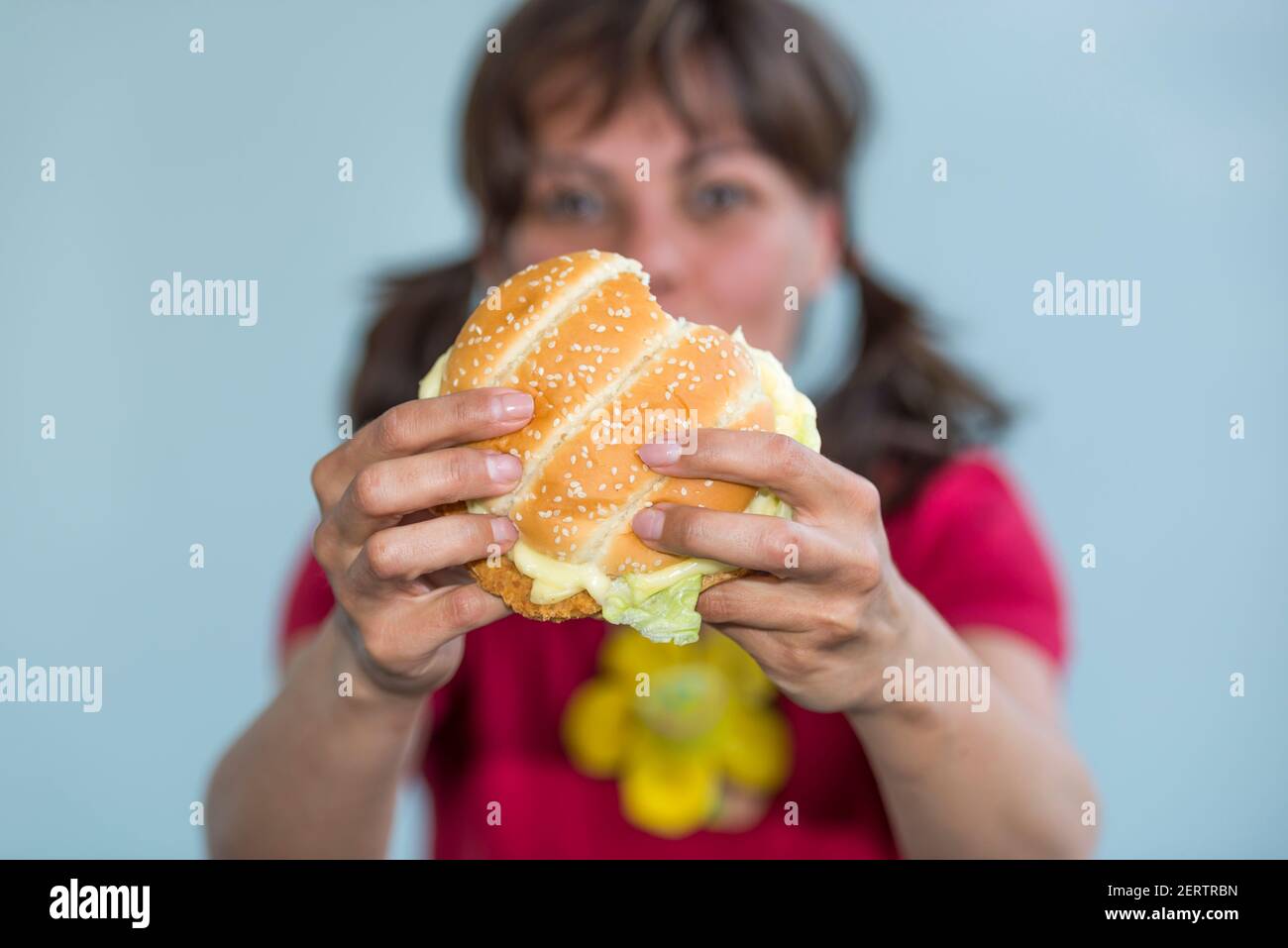 Woman Holding a Hamburger in Switzerland. Stock Photo