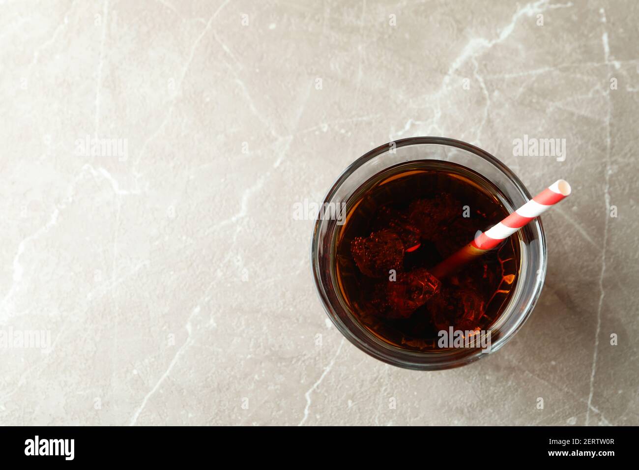 Glass of cola with ice cubes and straw on gray table Stock Photo - Alamy