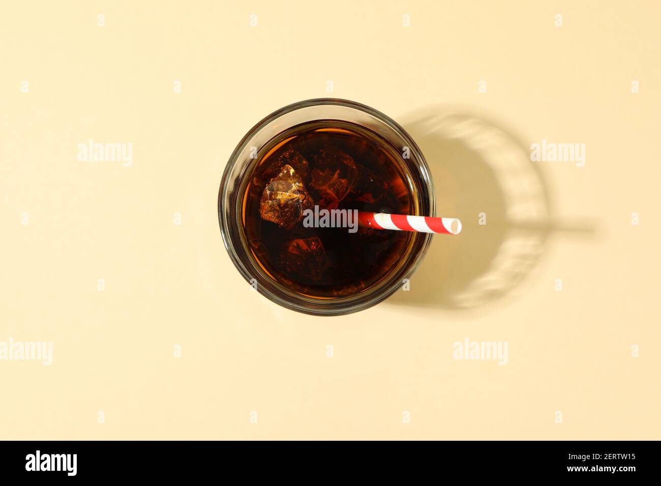 Glass of cola with ice cubes and straw on beige background Stock Photo ...