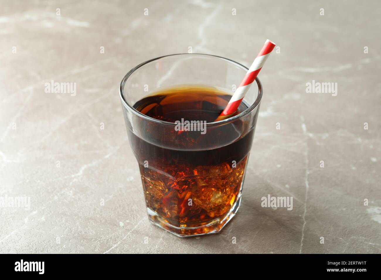 Glass of cola with ice cubes and straw on gray table Stock Photo - Alamy