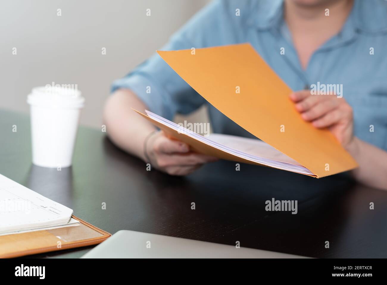 Businesswoman opening folder with paper documents Stock Photo - Alamy